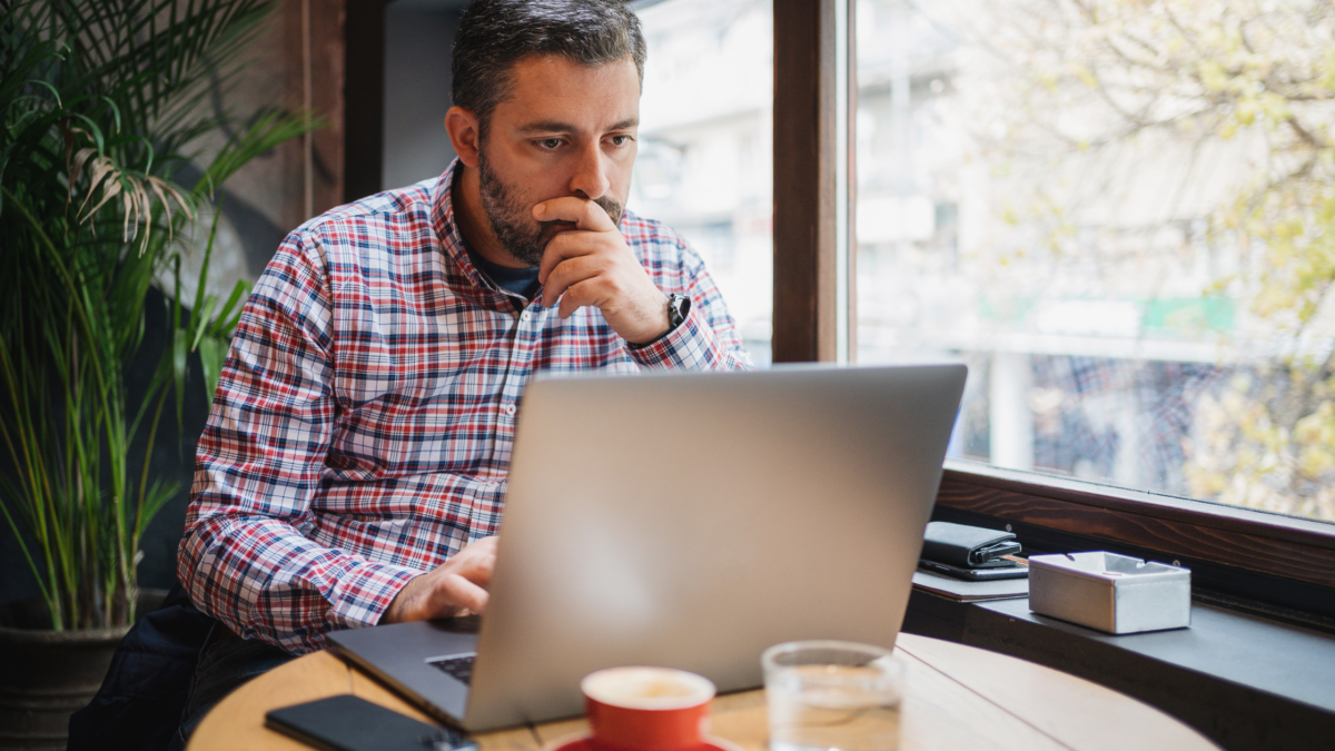 B2B startup founder comparing website messaging with customer feedback on a laptop