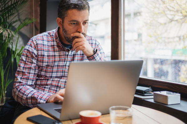B2B startup founder comparing website messaging with customer feedback on a laptop